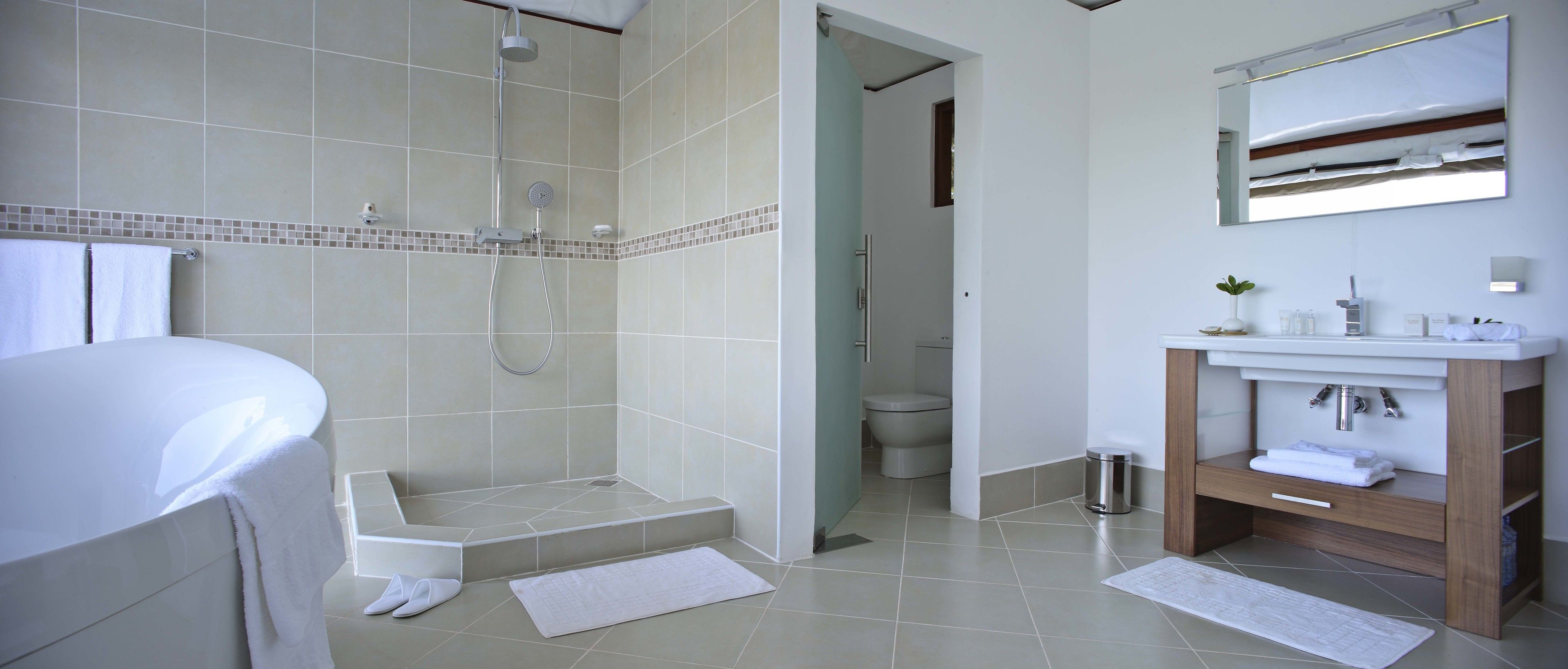 Un baño moderno con ducha, inodoro y lavamanos.