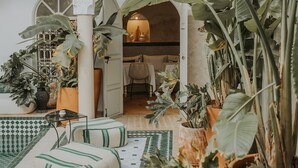Une cour spacieuse avec une piscine, des plantes en pot et un coin repas.