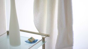 A bathroom with a glass shelf holding a bar of soap and a towel. - Ngerende in the Wild Riverview (Maasai Mara)