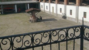 A courtyard with a central fountain, a covered seating area, and a building with multiple windows and columns. - Bed & Breakfast Cascina Bellezza (Poirino)