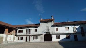 A two-story building with a central entrance, multiple windows, and a balcony. - Bed & Breakfast Cascina Bellezza (Poirino)