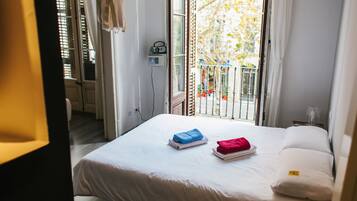 Habitación de hotel con cama, ventana con vista al exterior y radio en la pared.