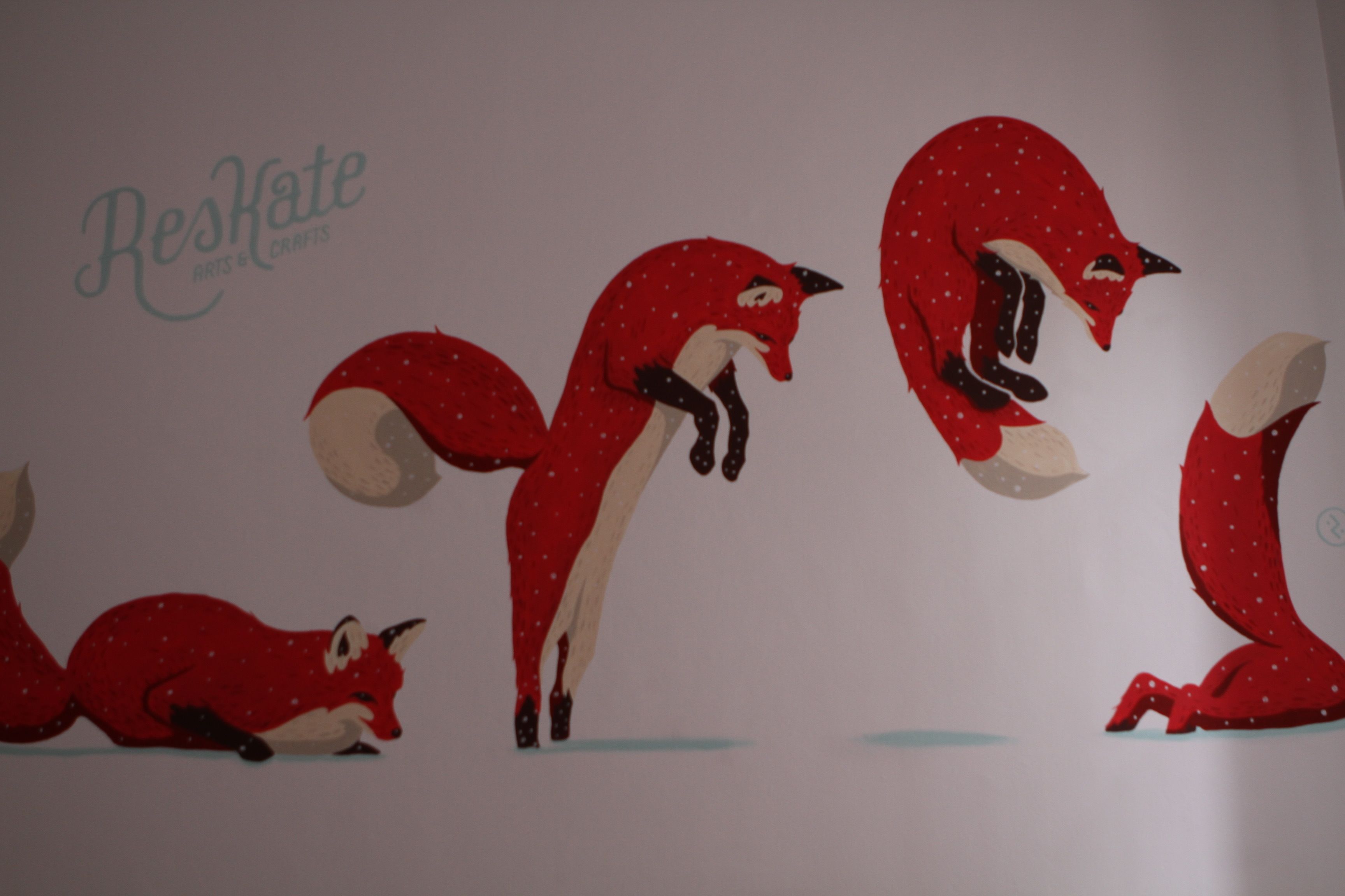 A wall with three red foxes and the text "Reskate Arts & Crafts".