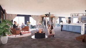 A spacious lobby with a central fire feature, seating areas, and a reception desk. - Hotel Slottsgården (Vadstena)