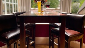 A dining table with a bottle, a glass, and a wine glass.