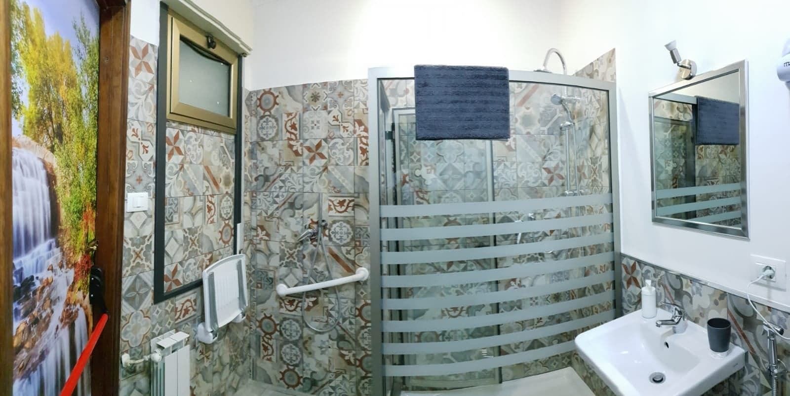 A bathroom with a shower area, a sink, and a mirror.