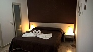 A hotel room with a large bed, two bedside lamps, and a wall with a starry pattern. - Nettuno (Messina)