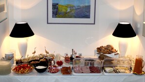 A buffet table with various food items and a painting on the wall. - Hotel Ebnet Garni (Lindau)