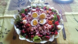 Ein Salat mit verschiedenen Zutaten und einem Teller auf einer Tischdecke.