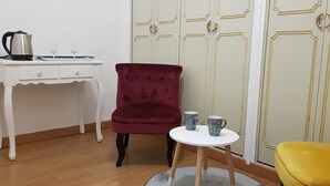 A room with a white desk, a red chair, a small round table with two mugs, and a yellow chair. - Chambre d Hote Chez Vero (Aubagne)