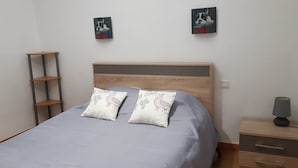 A bedroom with a bed, two pillows, a bedside table with a lamp, and two wall-mounted pictures. - Chambre d Hote Chez Vero (Aubagne)