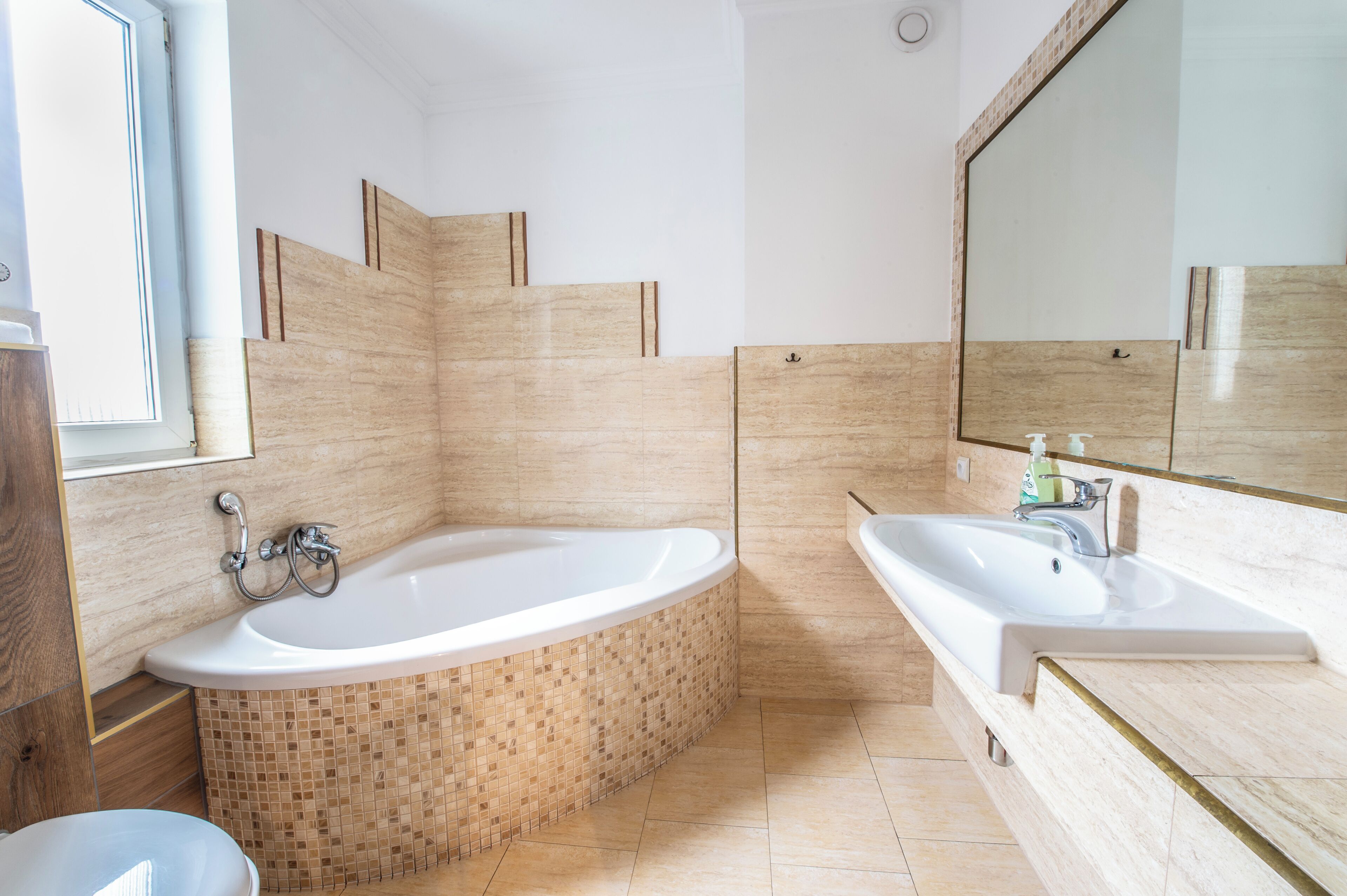A modern bathroom with a freestanding bathtub, a large mirror, and a sink.