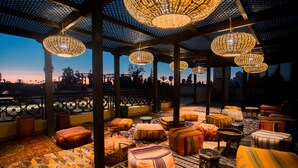A rooftop lounge area with multiple seating options and hanging wicker lamps. - Palais Dar Si Aissa ALL-SUITES (Marrakech)