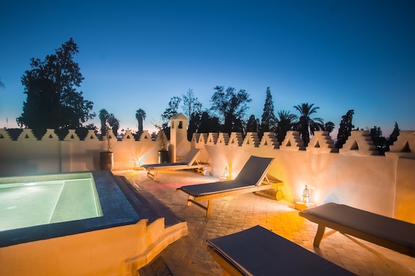 Una piscina al aire libre, sillones reclinables de piscina