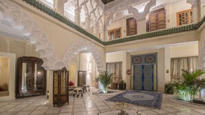 A spacious lobby with high ceilings, intricate arches, and a central fountain. - Palais Dar Si Aissa ALL-SUITES (Marrakech)