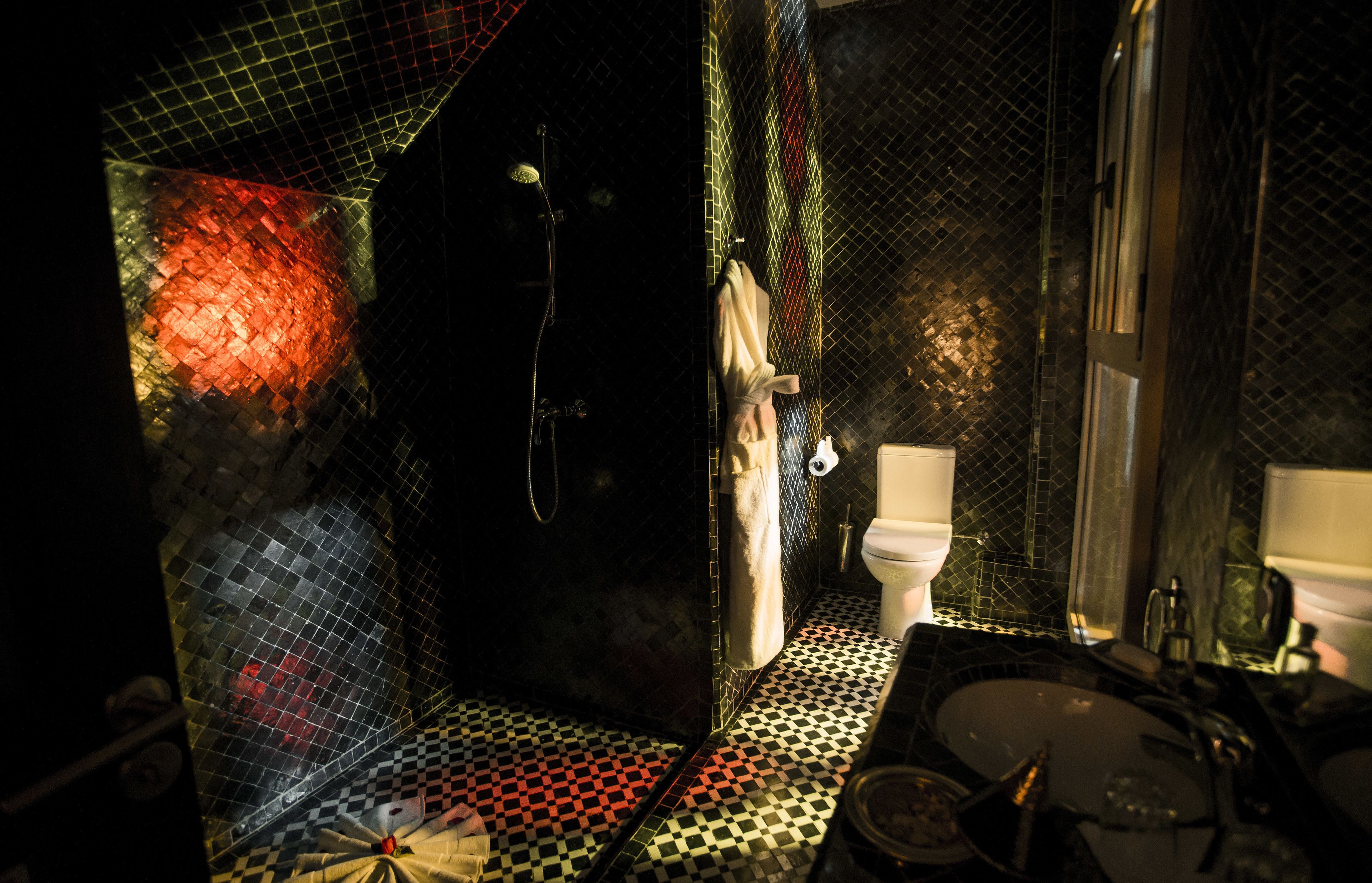 Ein Badezimmer mit Schachbrettboden, Toilette und Dusche.