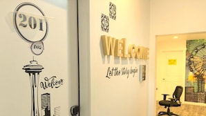 A hotel entrance with a '201' sign, a 'Welcome' sign, and a 'Let the story begin' sign on the wall. - The ART INN Seattle (Seattle)
