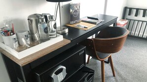 A compact kitchenette with a coffee maker, kettle, and microwave. There is a chair and a small refrigerator. - The ART INN Seattle (Seattle)