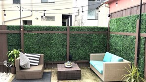 A patio area with wicker furniture, a small table, and a potted plant. - The ART INN Seattle (Seattle)