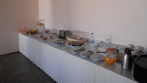 A buffet setup with various food items and beverages. - Hotel Milton (East Mani)