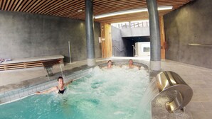An indoor swimming pool with a wooden ceiling and a hot tub area. - Village Cévéo de Luz-Saint-Sauveur (Luz-Saint-Sauveur)