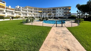 Un edificio residencial de varios pisos con una piscina en el centro.