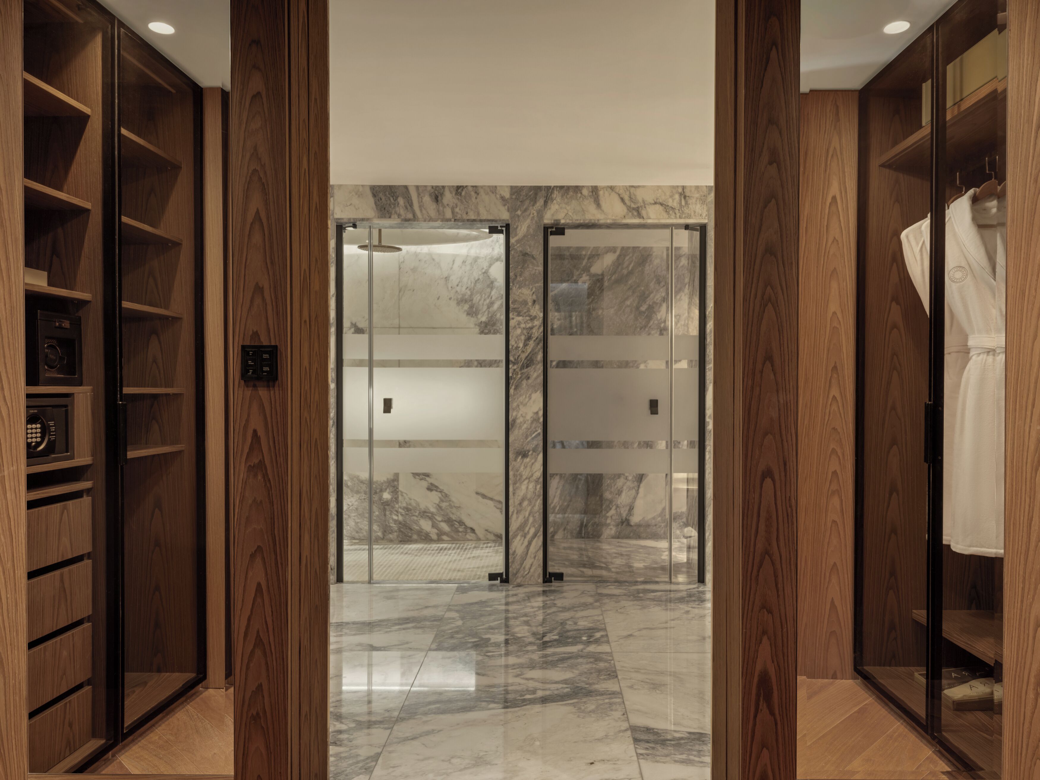 A modern interior with wooden shelving, a marble floor, and a glass door entrance.