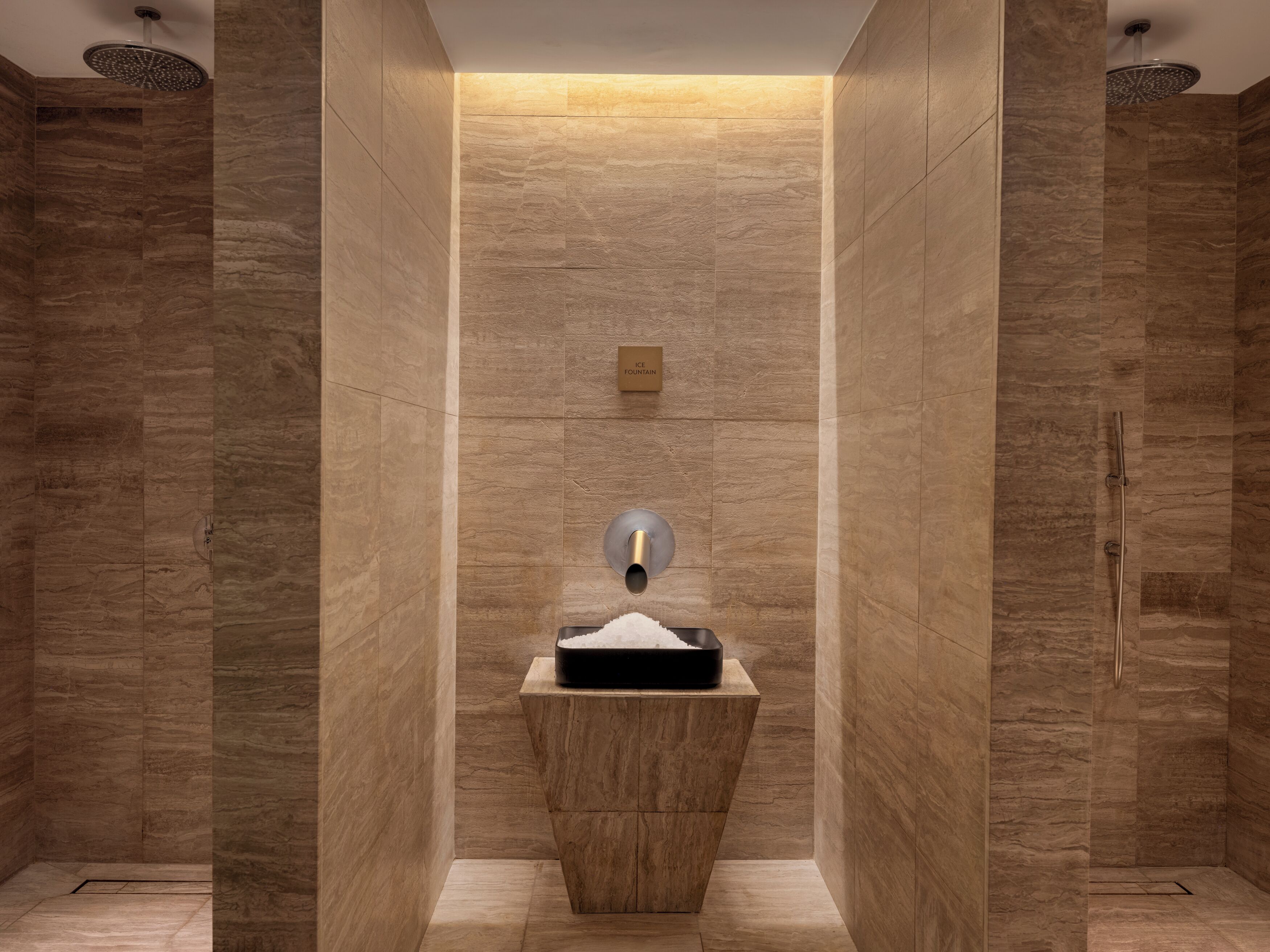 A modern bathroom with a central sink, a towel rack, and a showerhead.