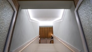 Una escalera con techo de madera y tragaluz que da a un cuarto con una puerta.