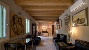 Un amplio salón con chimenea, sofás de cuero y obras de arte en las paredes.