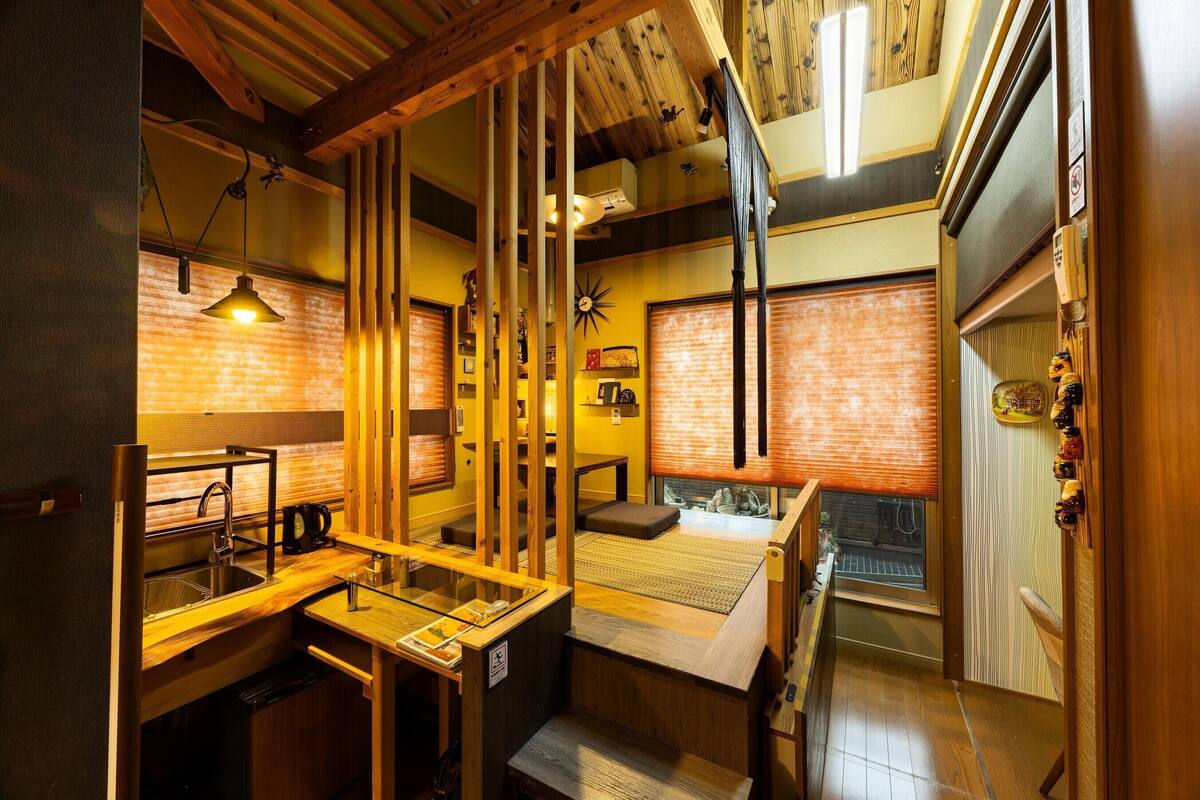 A compact kitchen with a sink, countertop, and wooden beams.
