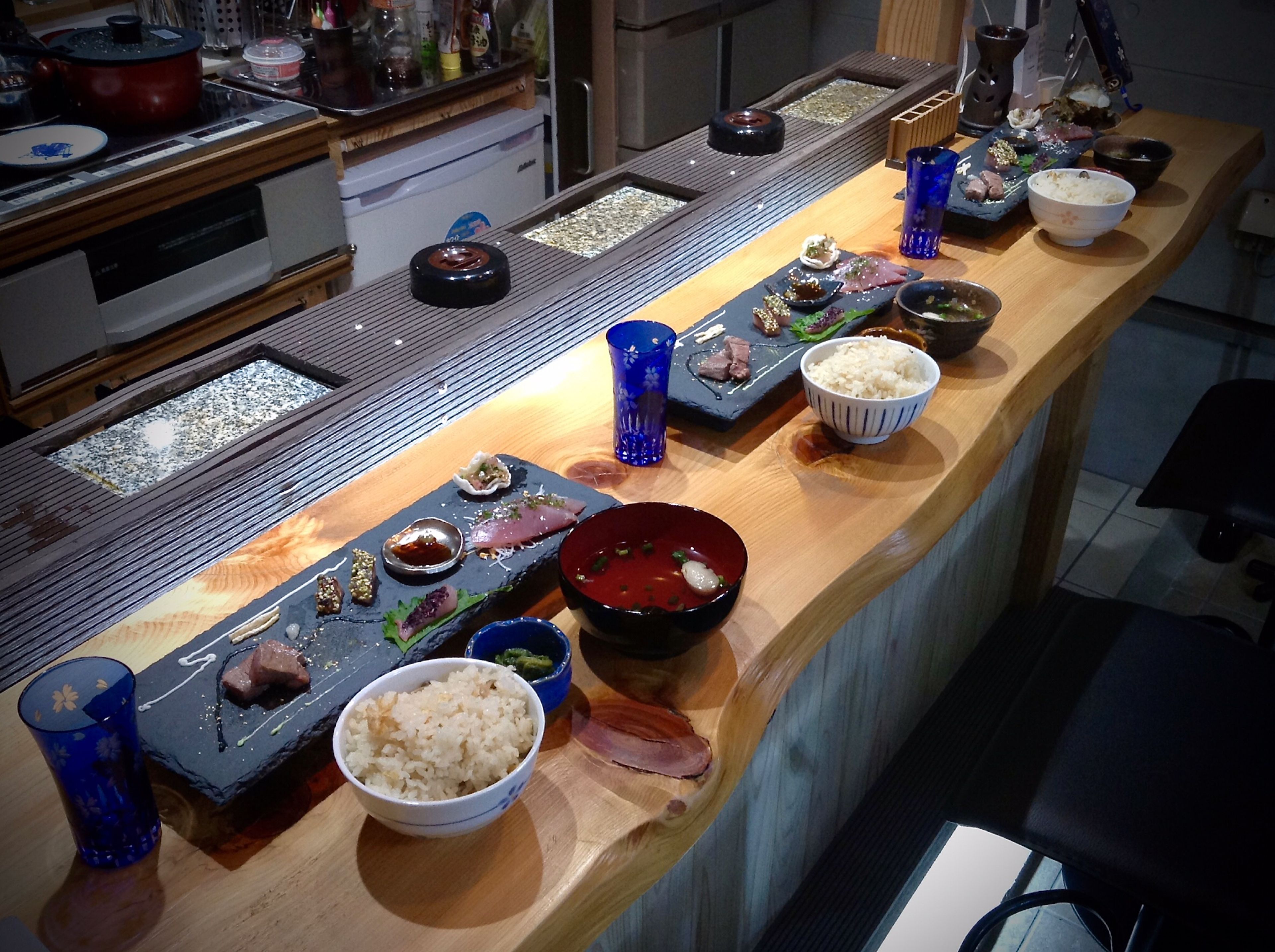 Un bar de sushi con diferentes platos y bebidas.