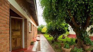 A brick building with a wooden door labeled "INFLY 9". - Nelly's Guesthouse (Lilongwe)