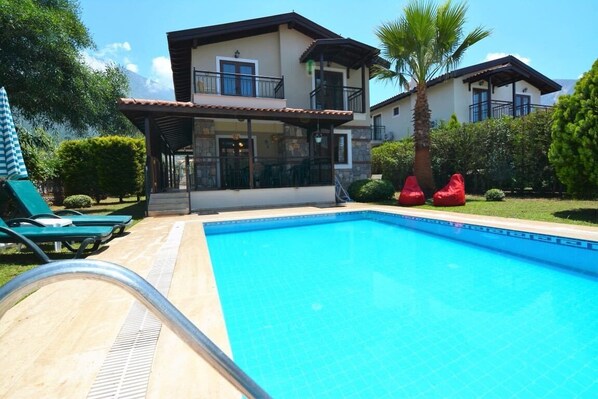Piscine extérieure, parasols de plage, chaises longues