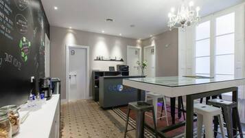 Een moderne hotelkamer met een glazen tafel, een kroonluchter en een vloer met een patroon.