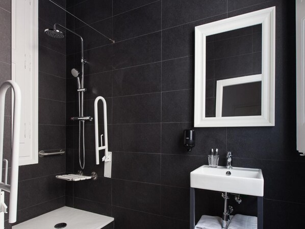 A modern bathroom with a shower, a sink, and a mirror.