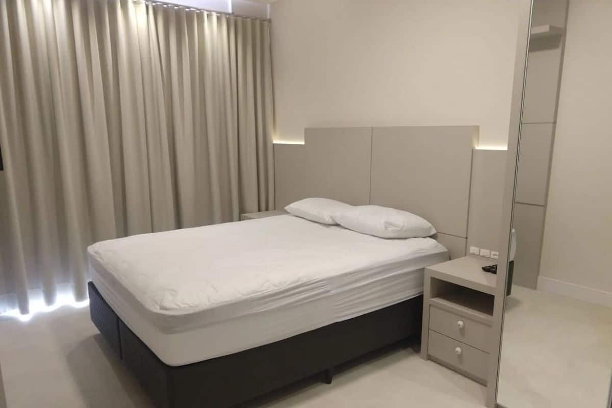 Ein modernes Schlafzimmer mit Bett, Nachttisch und Spiegel.