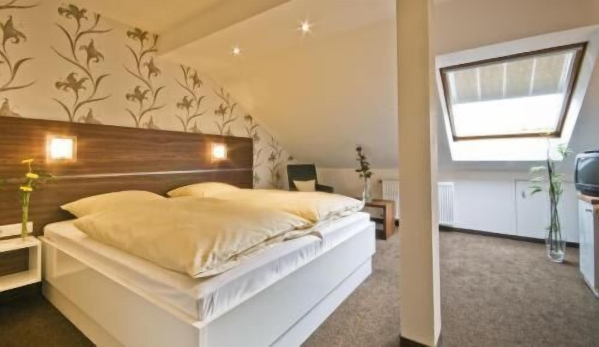 Une chambre à coucher avec un lit, une table de chevet, un bureau et une fenêtre.