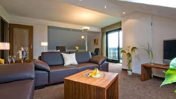 Suite junior, 1 cama matrimonial, para no fumadores | Área de sala de estar | Televisión