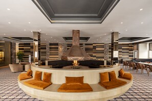 A modern lounge area with a central fire feature, seating with cushions, and a patterned floor. - Jura Hotels Kervansaray Uludag  (Bursa)