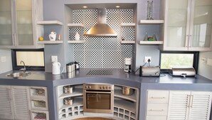 A compact kitchen with a built-in oven, a coffee maker, and a toaster. - 10 Martingale (Knysna)