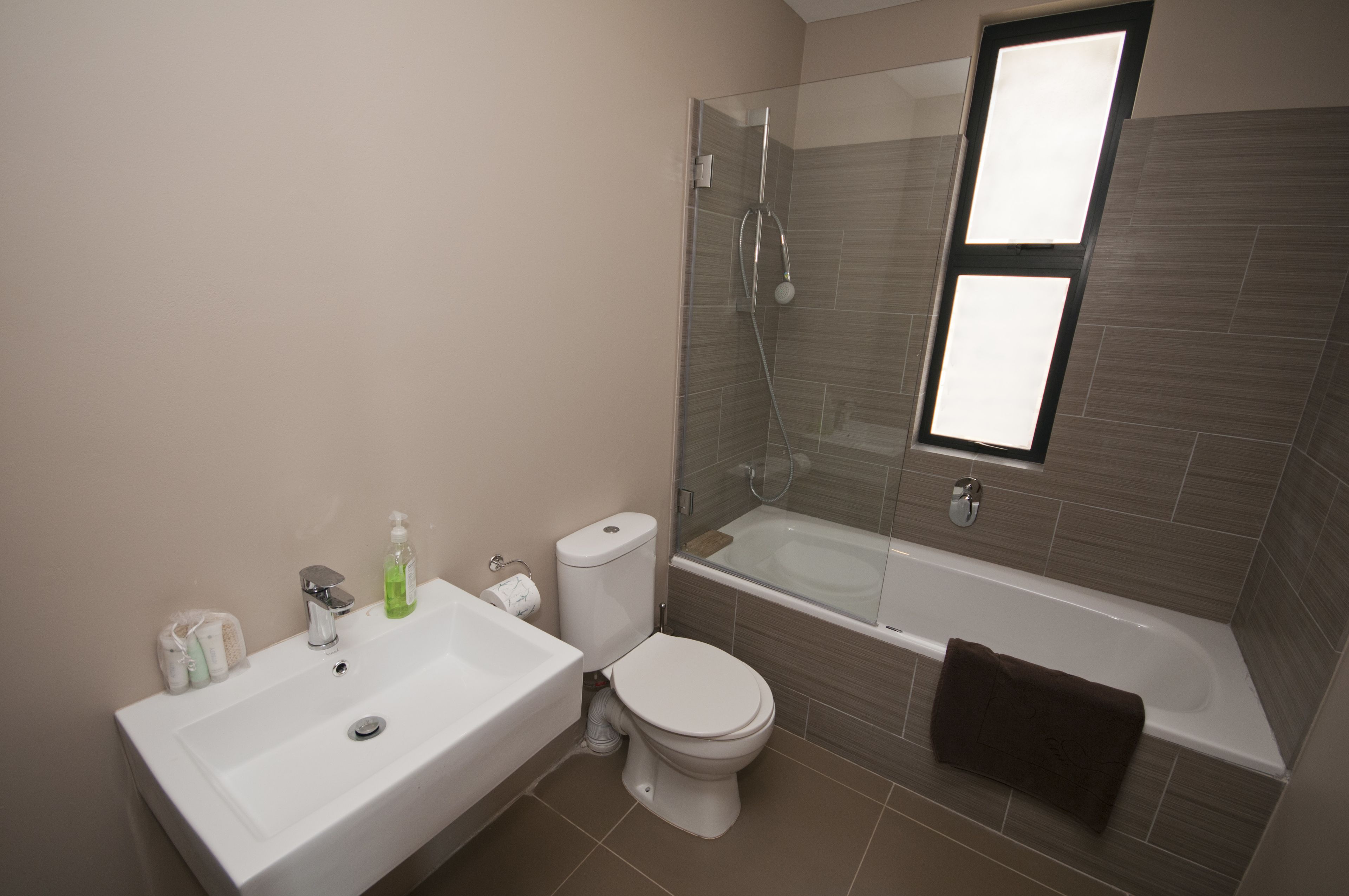 A modern bathroom with a white sink, toilet, and bathtub.