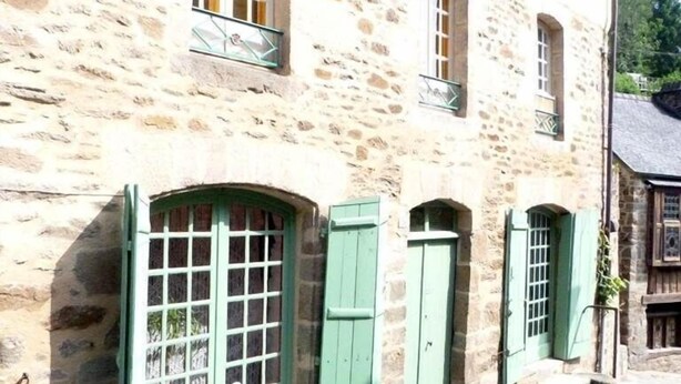 A stone building with multiple windows and green shutters. - Le Logis du Jerzual (Dinan)