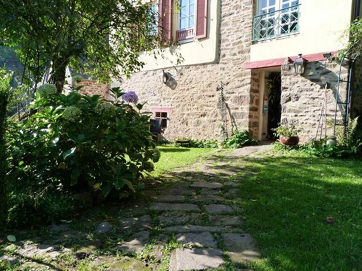 A stone building with a garden path leading to a door.