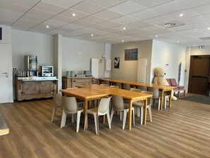 A dining area with wooden tables and chairs, a coffee machine, and a refrigerator. - Résidence Cévéo du Pleynet (Le Haut-Bréda)