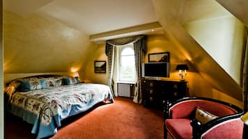 A bedroom with a bed, a dresser, a television, and a chair.