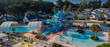 Alberca techada, alberca al aire libre y sombrillas en la alberca