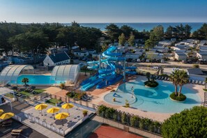 A water park with multiple slides and pools, surrounded by villas and a beach. - Yelloh Village La Plage (Penmarch)