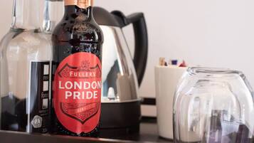 A bottle of London Pride gin, a glass, and a coffee maker on a table.