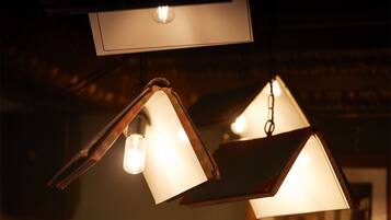 Teto com várias luminárias pendentes, incluindo um design triangular único e formato retangular.